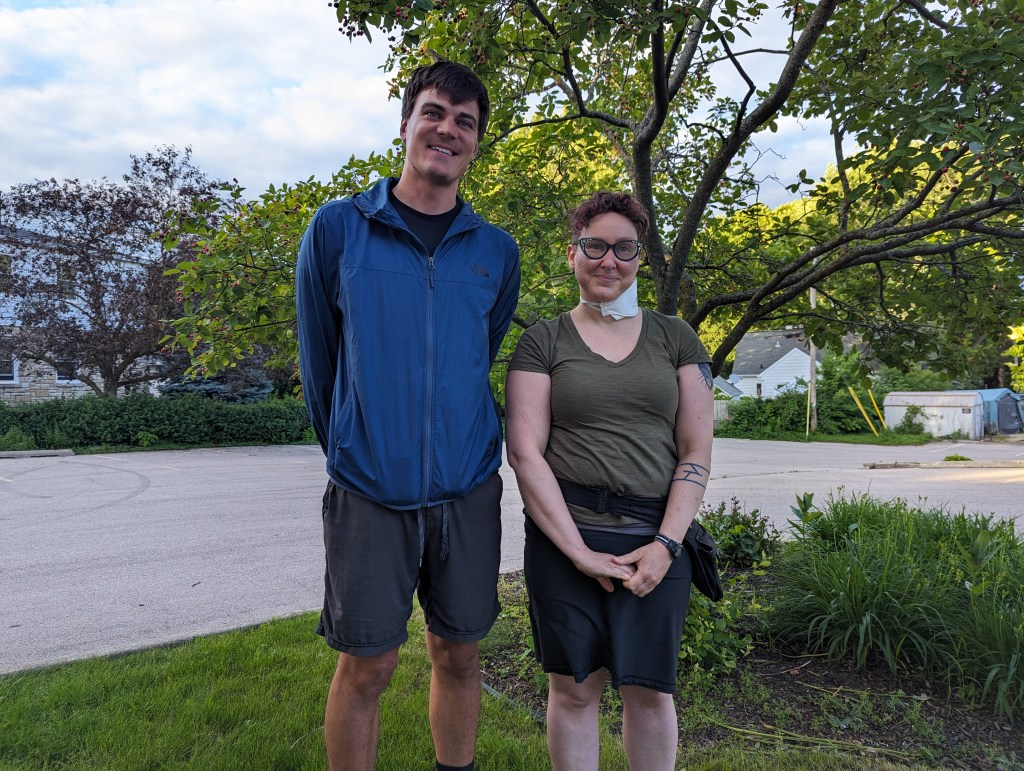 Two people are standing in front of a tree. A representative from Friends of Starkweather Creek is on the left; a cochair of the neighborhood association is on the right. 